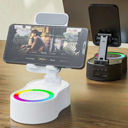Soporte multifuncional blanco con altavoz Bluetooth, luz RGB, batería interna y base ajustable para teléfonos y tablets.